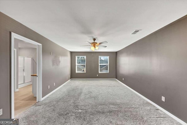 spare room featuring visible vents, carpet flooring, baseboards, and a ceiling fan