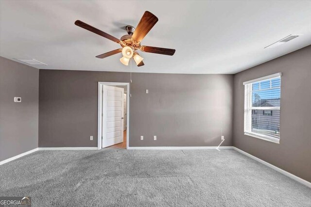 empty room featuring visible vents, baseboards, and carpet