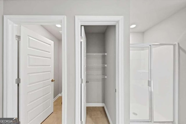 full bathroom with baseboards and a shower stall