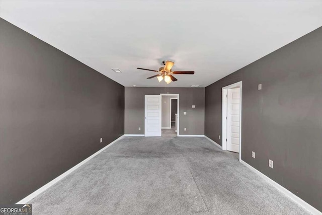 carpeted empty room featuring visible vents, baseboards, and a ceiling fan