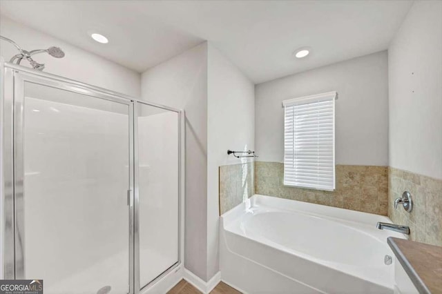 bathroom featuring a shower stall, a bath, and recessed lighting