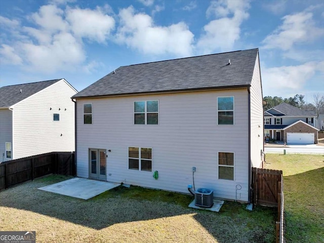 rear view of property with a patio area, a lawn, a shingled roof, and a fenced backyard