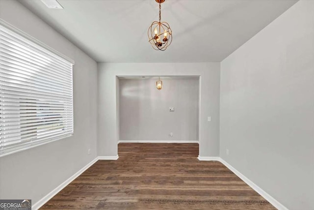 interior space with a chandelier, baseboards, and wood finished floors