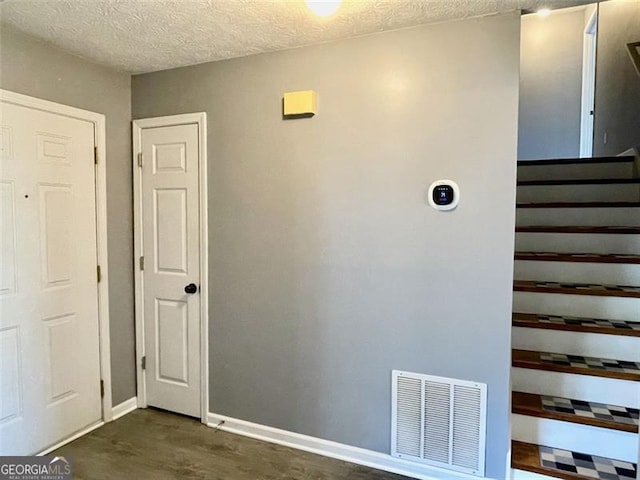 interior space with baseboards, visible vents, and a textured ceiling