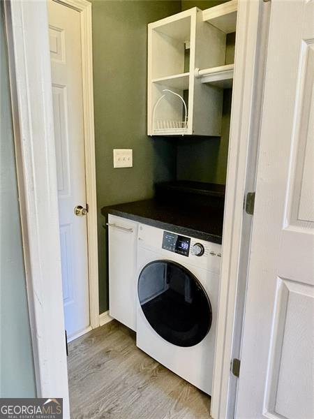 laundry room featuring light wood finished floors and washer / clothes dryer