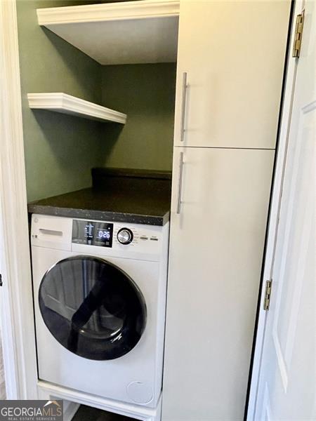 washroom featuring laundry area and washer / dryer