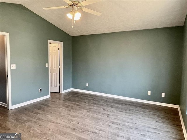 empty room with vaulted ceiling, baseboards, a ceiling fan, and wood finished floors