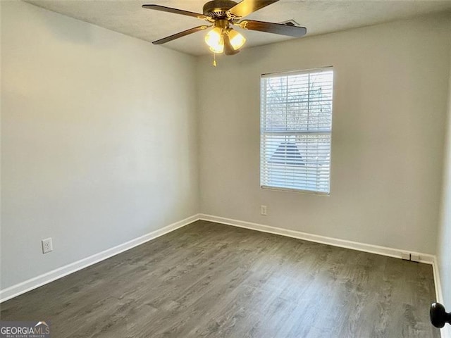 empty room with ceiling fan, baseboards, and dark wood finished floors