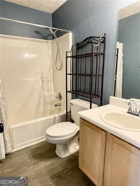 full bath featuring shower / tub combo with curtain, toilet, a textured ceiling, wood finished floors, and vanity