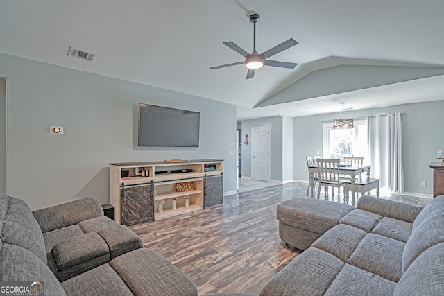 living area featuring visible vents, wood finished floors, baseboards, ceiling fan, and vaulted ceiling