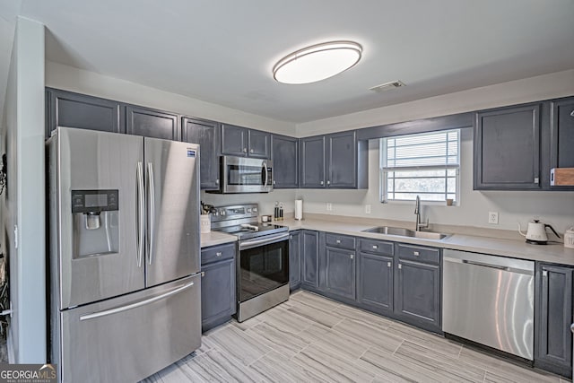 kitchen with a sink, visible vents, appliances with stainless steel finishes, and light countertops