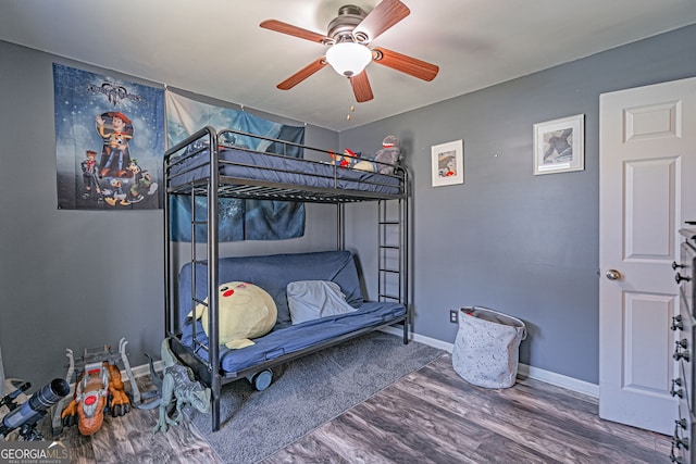 bedroom with ceiling fan, baseboards, and wood finished floors