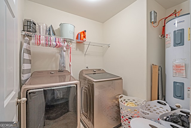 clothes washing area featuring laundry area, electric water heater, and separate washer and dryer