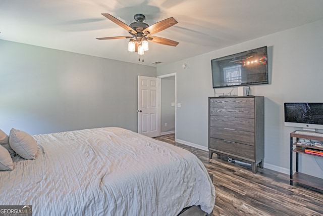 bedroom with a ceiling fan, baseboards, and wood finished floors