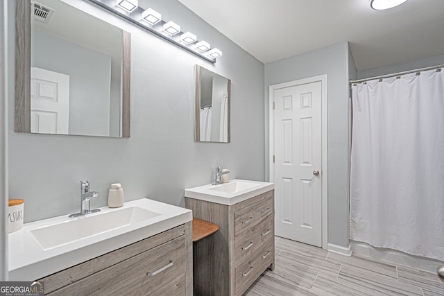 full bathroom with a sink, visible vents, and two vanities