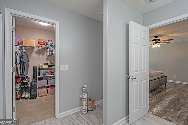 bathroom featuring ceiling fan, baseboards, and wood finished floors