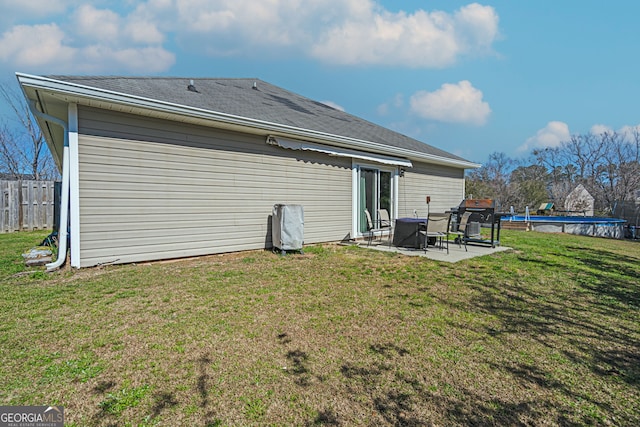 rear view of property with a patio area, a fenced in pool, a yard, and fence