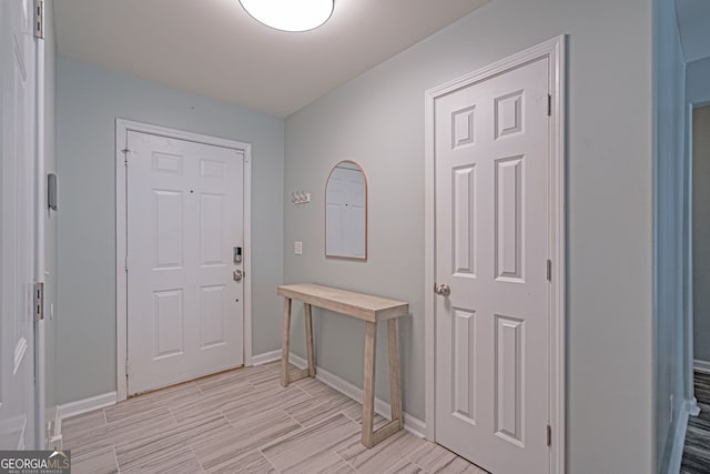 entrance foyer with baseboards and wood tiled floor