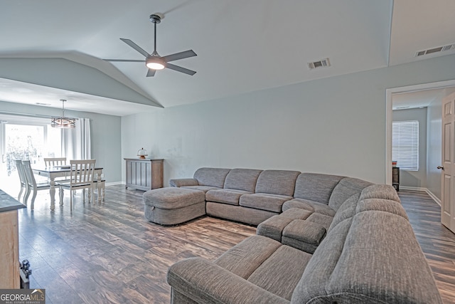 living area with visible vents, dark wood-type flooring, a ceiling fan, and vaulted ceiling