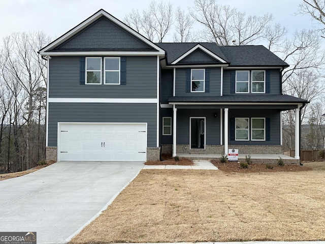 craftsman-style house featuring brick siding, a porch, an attached garage, and concrete driveway