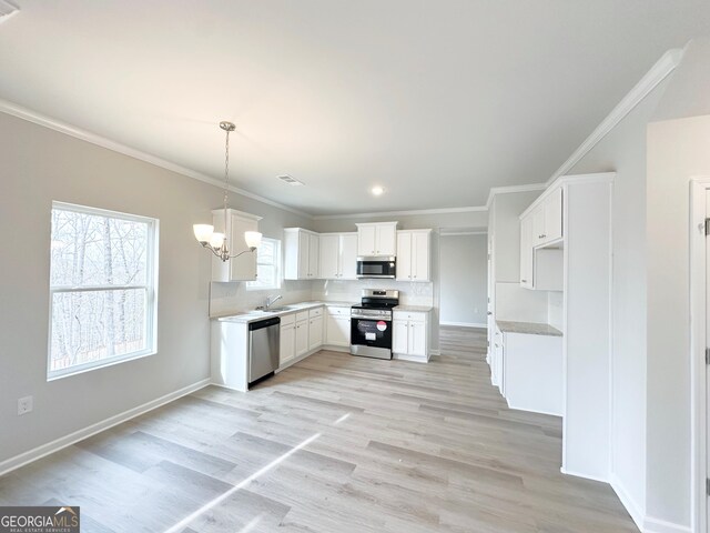 kitchen featuring light wood finished floors, visible vents, stainless steel appliances, and crown molding