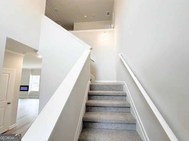 staircase with visible vents, baseboards, and wood finished floors