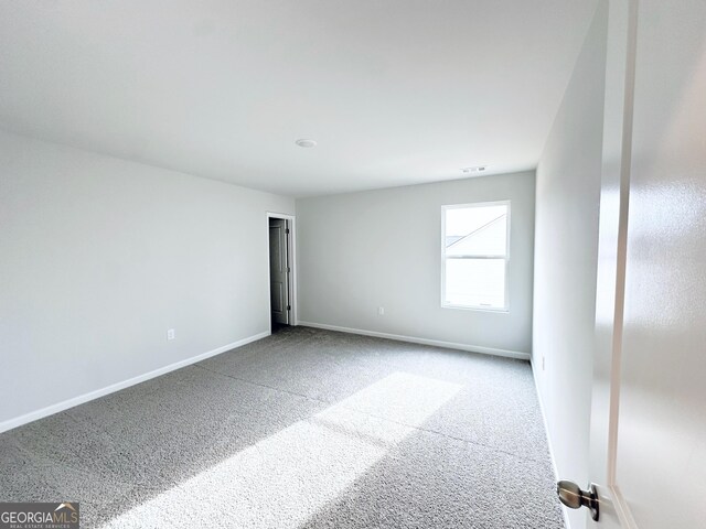 unfurnished room with baseboards, carpet floors, and visible vents