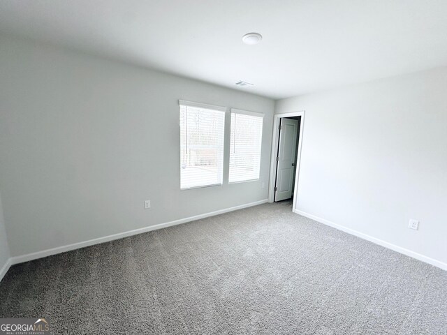 unfurnished room featuring visible vents, baseboards, and carpet floors