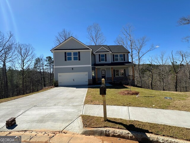 view of front facade featuring a front lawn, an attached garage, and driveway