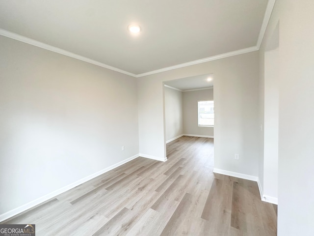 unfurnished room with wood finished floors, baseboards, and ornamental molding