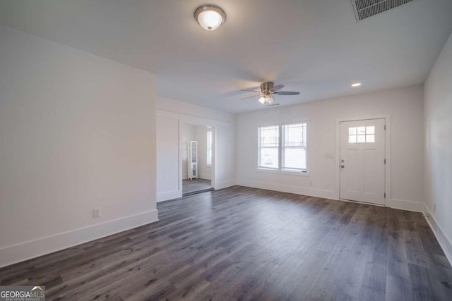 unfurnished living room with dark wood finished floors, baseboards, and visible vents