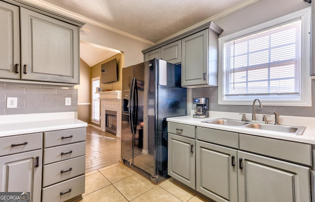 kitchen featuring a sink, black refrigerator with ice dispenser, and gray cabinetry