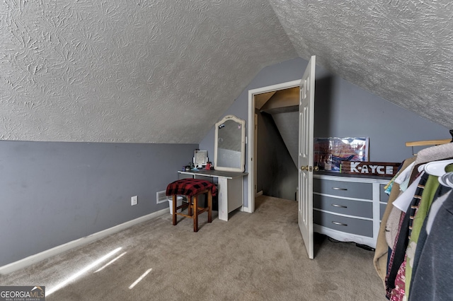 bedroom featuring baseboards, a textured ceiling, lofted ceiling, and carpet floors