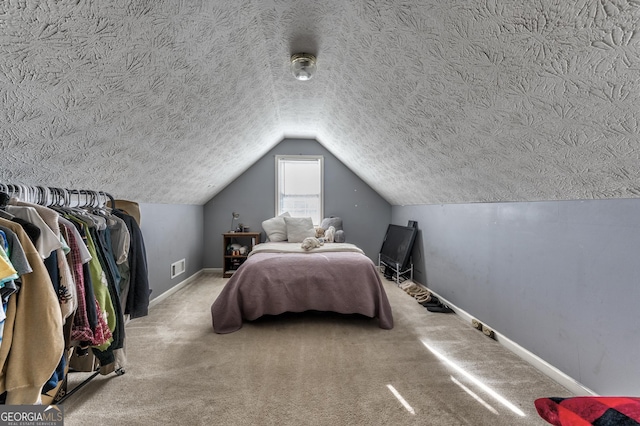 bedroom with vaulted ceiling, carpet flooring, visible vents, and baseboards