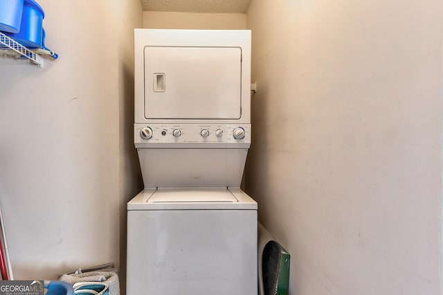 laundry area with stacked washer / dryer and laundry area