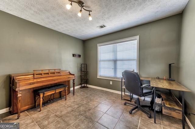 tiled office with baseboards, visible vents, and a textured ceiling