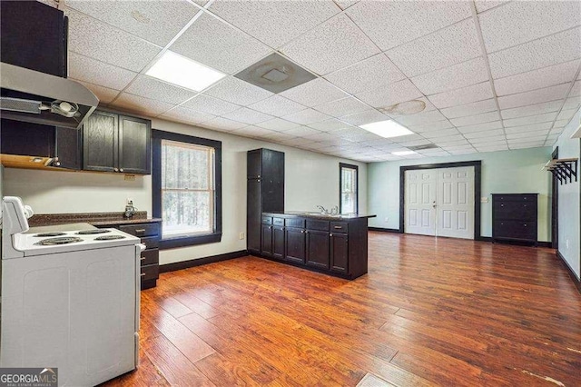 kitchen with extractor fan, white range with electric cooktop, a peninsula, wood finished floors, and a paneled ceiling