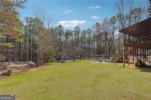 view of yard featuring a deck, stairway, and a patio area