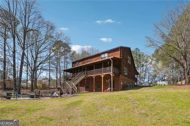 back of house featuring stairway, a lawn, and a wooden deck