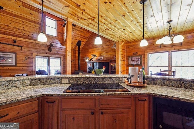 kitchen with wooden walls, pendant lighting, stone counters, wooden ceiling, and black electric cooktop