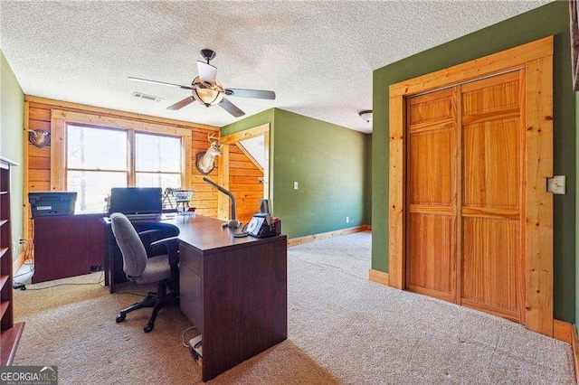 home office featuring visible vents, carpet, a ceiling fan, and a textured ceiling