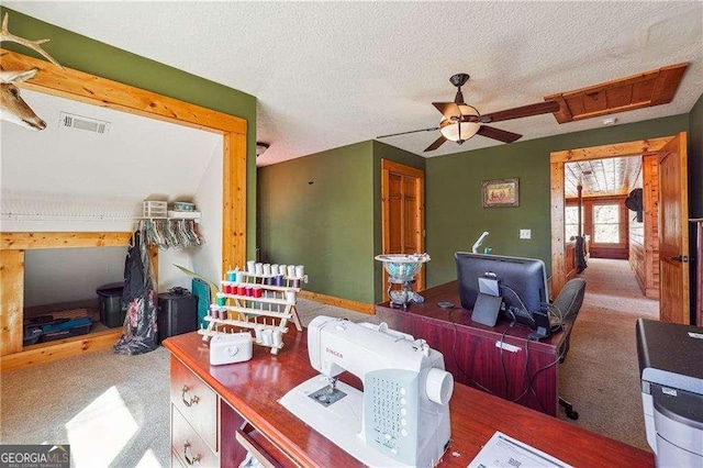 office area with visible vents, a textured ceiling, a ceiling fan, and carpet floors