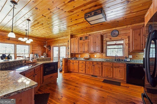 kitchen with brown cabinets, black appliances, a sink, wood-type flooring, and wood ceiling