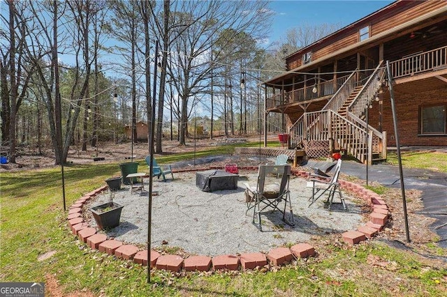 view of yard featuring a fire pit and stairs