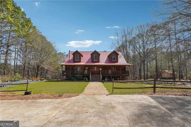 view of front of home featuring a porch, metal roof, and a front lawn