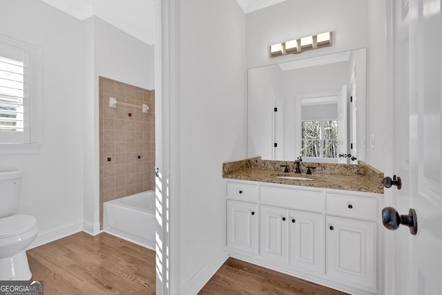 bathroom featuring toilet, a healthy amount of sunlight, and wood finished floors