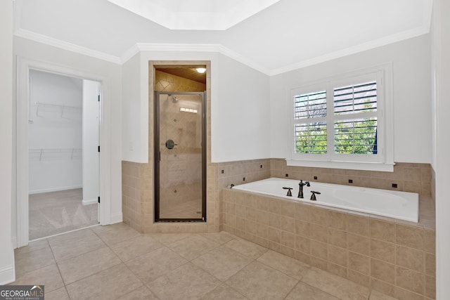 full bath featuring a stall shower, ornamental molding, tile patterned flooring, a walk in closet, and a garden tub