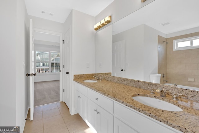 bathroom featuring tile patterned flooring, double vanity, toilet, and a sink