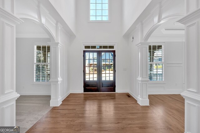 entryway featuring decorative columns, a healthy amount of sunlight, and arched walkways