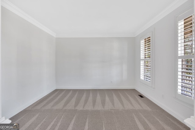 empty room with baseboards, carpet, and crown molding